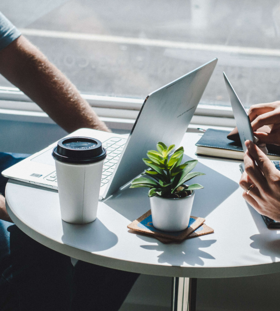 laptops and plant and coffee sitting on table