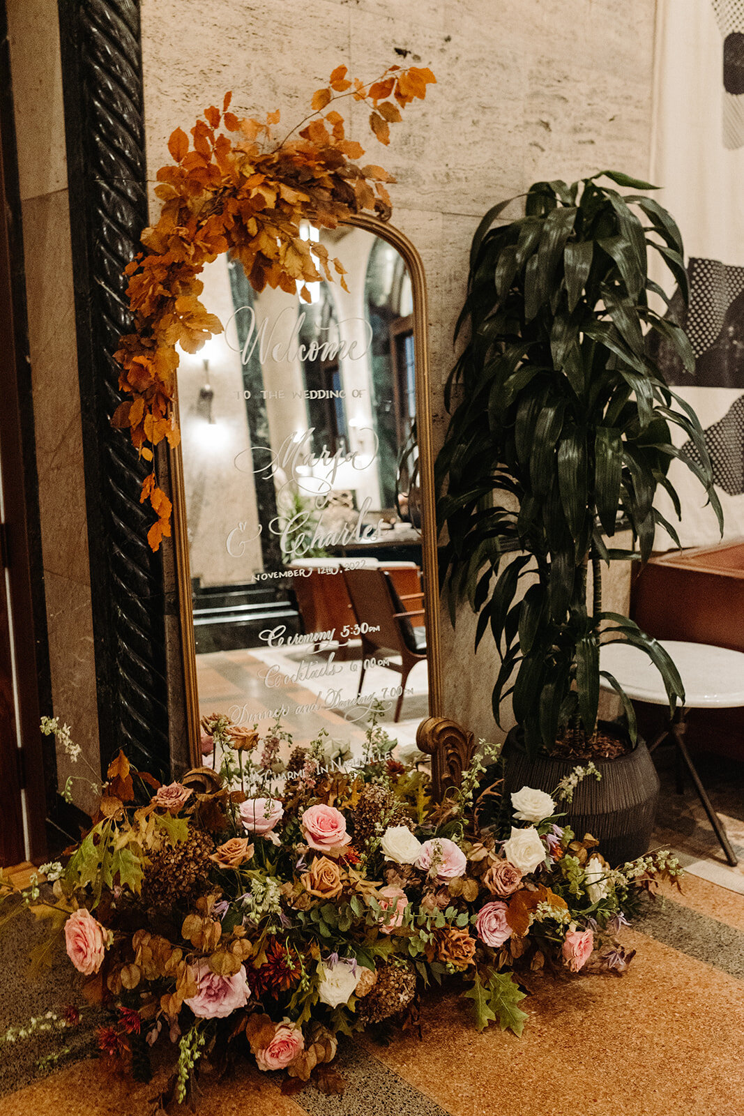 Tasteful cocktail hour florals create an inviting space in hues of dusty rose, burgundy, mauve, taupe, copper, and lavender. Florals composed of roses, clematis, lisianthus, spray roses, copper beech, and fall foliage. Design by Rosemary and Finch in Nashville, TN.