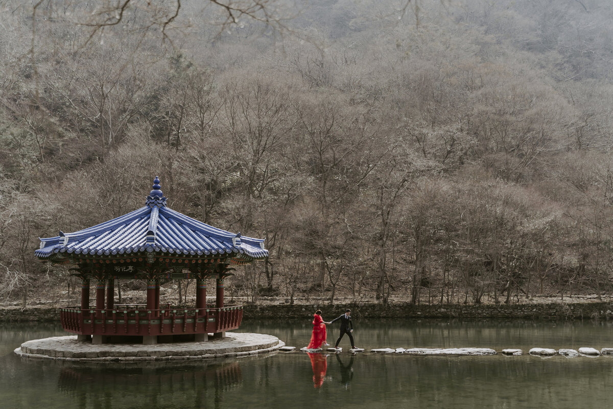 couple crossing the pond at Naejangsa in South Korea