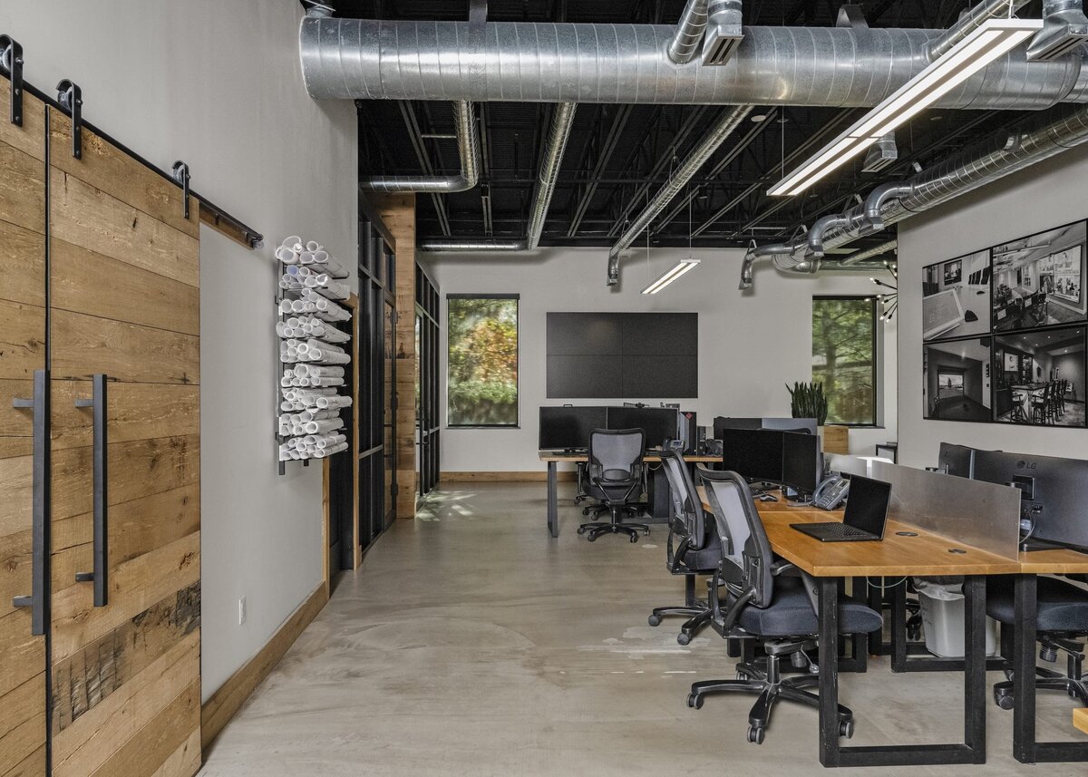 candra lynn interiors old bridge project industrial office with wooden desks and sliding barndoors