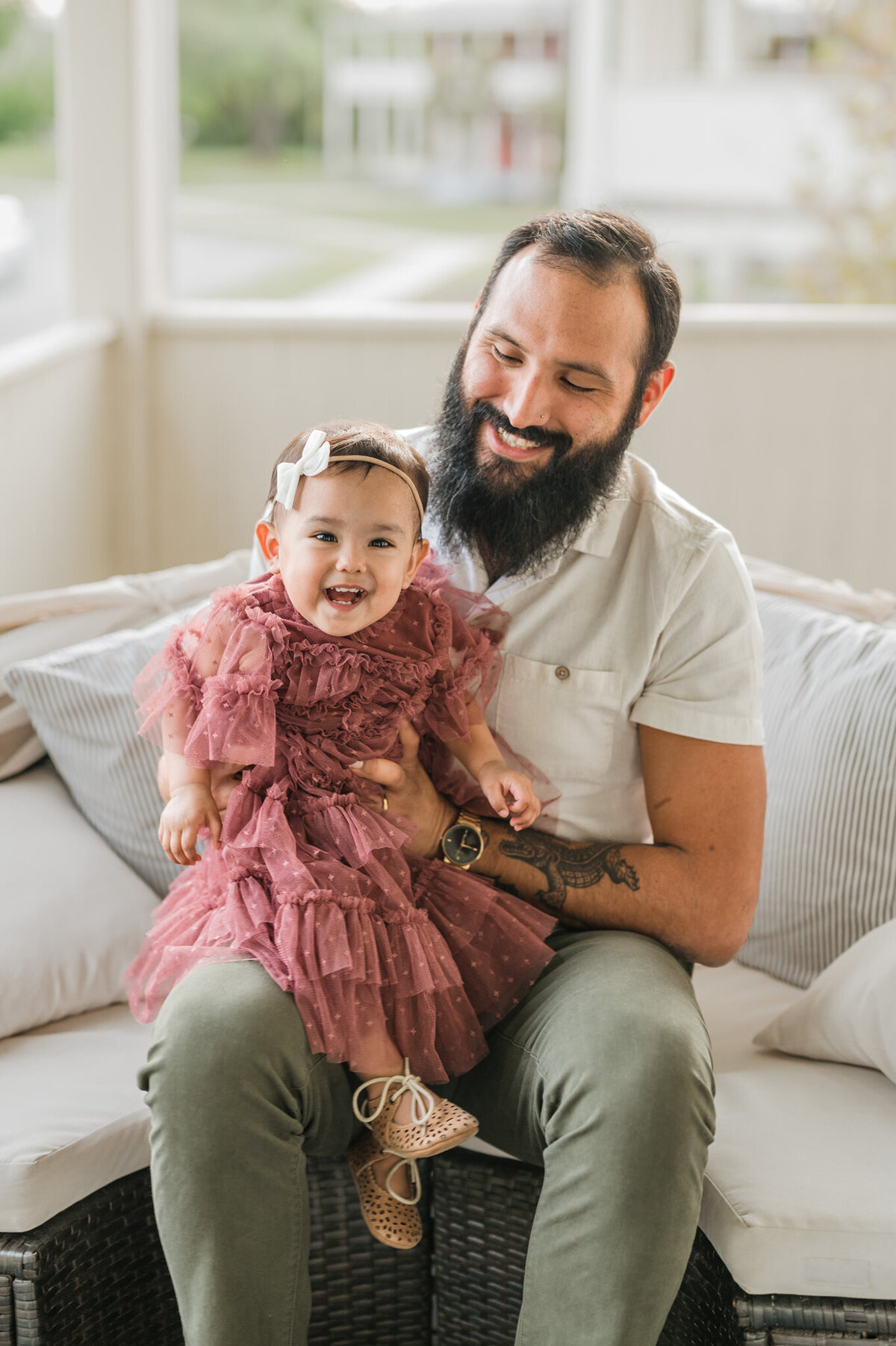 Toddler laughs on Dad's lap during family photography with Cassey Golden.