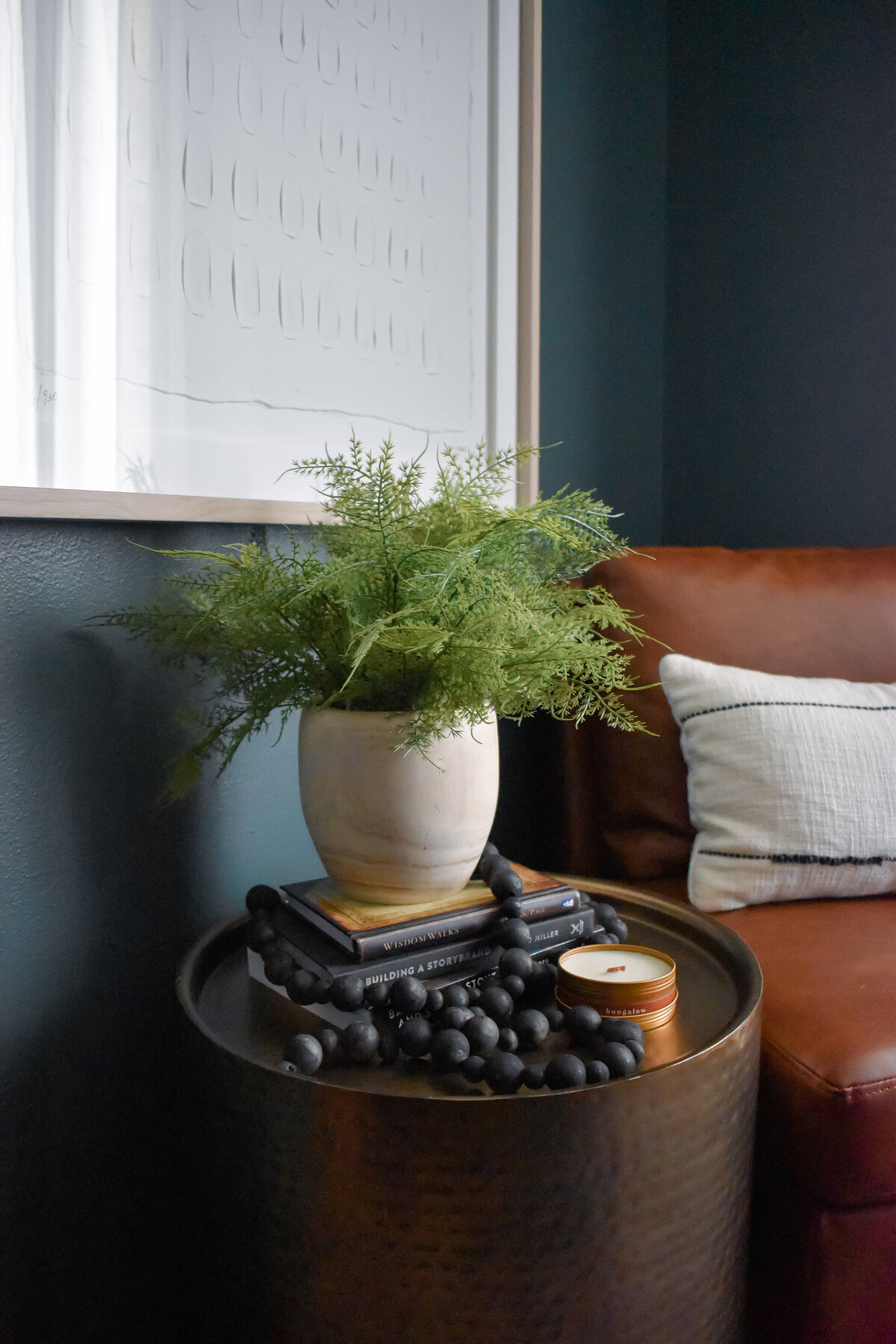 A round side table holds a potted plant