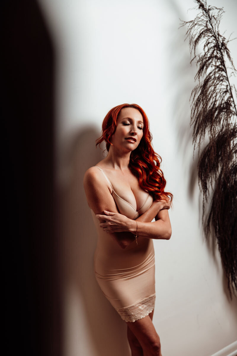 Boudoir portrait of red haired woman wearing nude slip dress