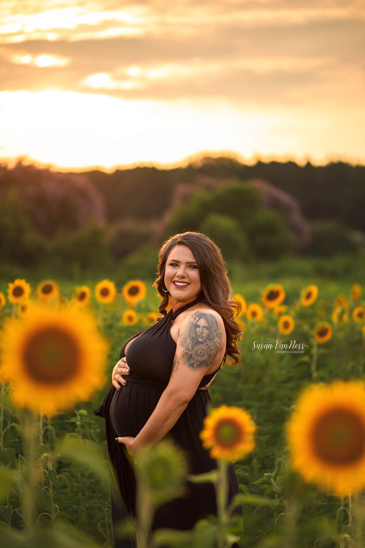 Maternity photos of pregnant mother in sunflowers at sunset