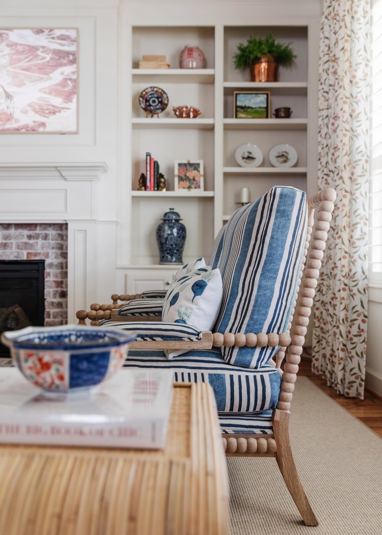 oyster creek studios oak forest remodel blue striped armchair and white shelving in living room