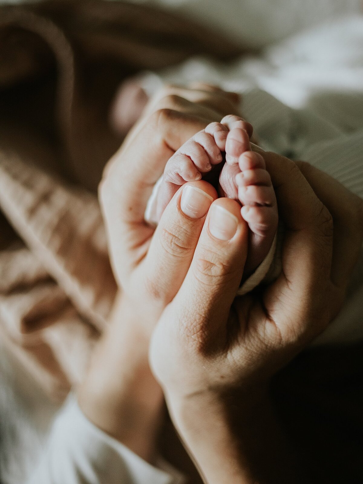parent holding baby's feet