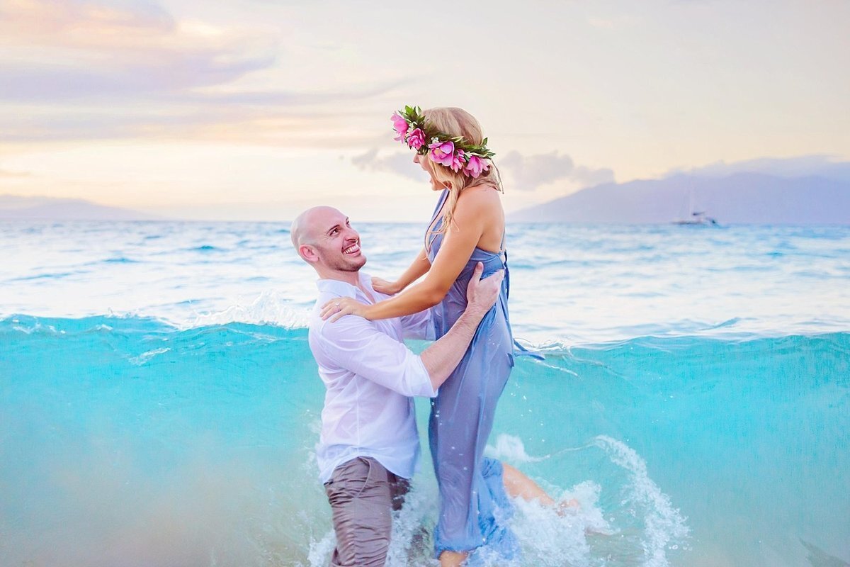 Engaged Maui couple is photographed from the ocean by Love + Water as they look in to eachother's eyes and laugh