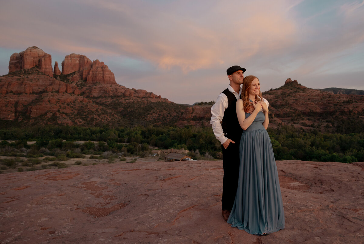 Couple standing against red rock backdrop during Sedona engagement session