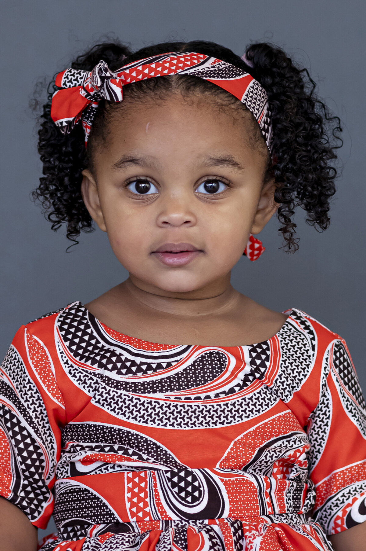 Girl in colourful dress sitting for her school photo