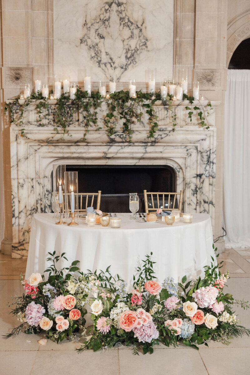 high-end sweetheart table flowers fireplace backdrop
