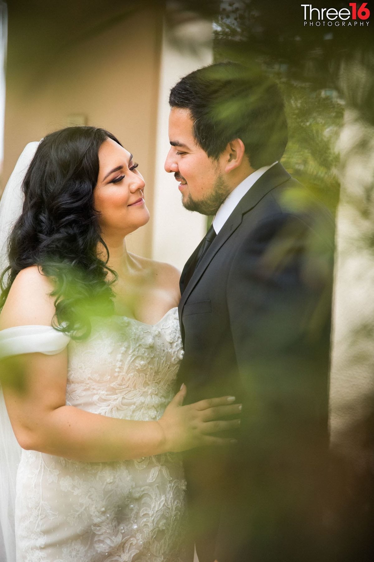 Bride and Groom share an intimate moment together behind some tree branches