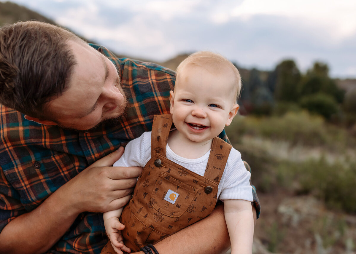 dad playing with his baby boy in the mountains of coloraod