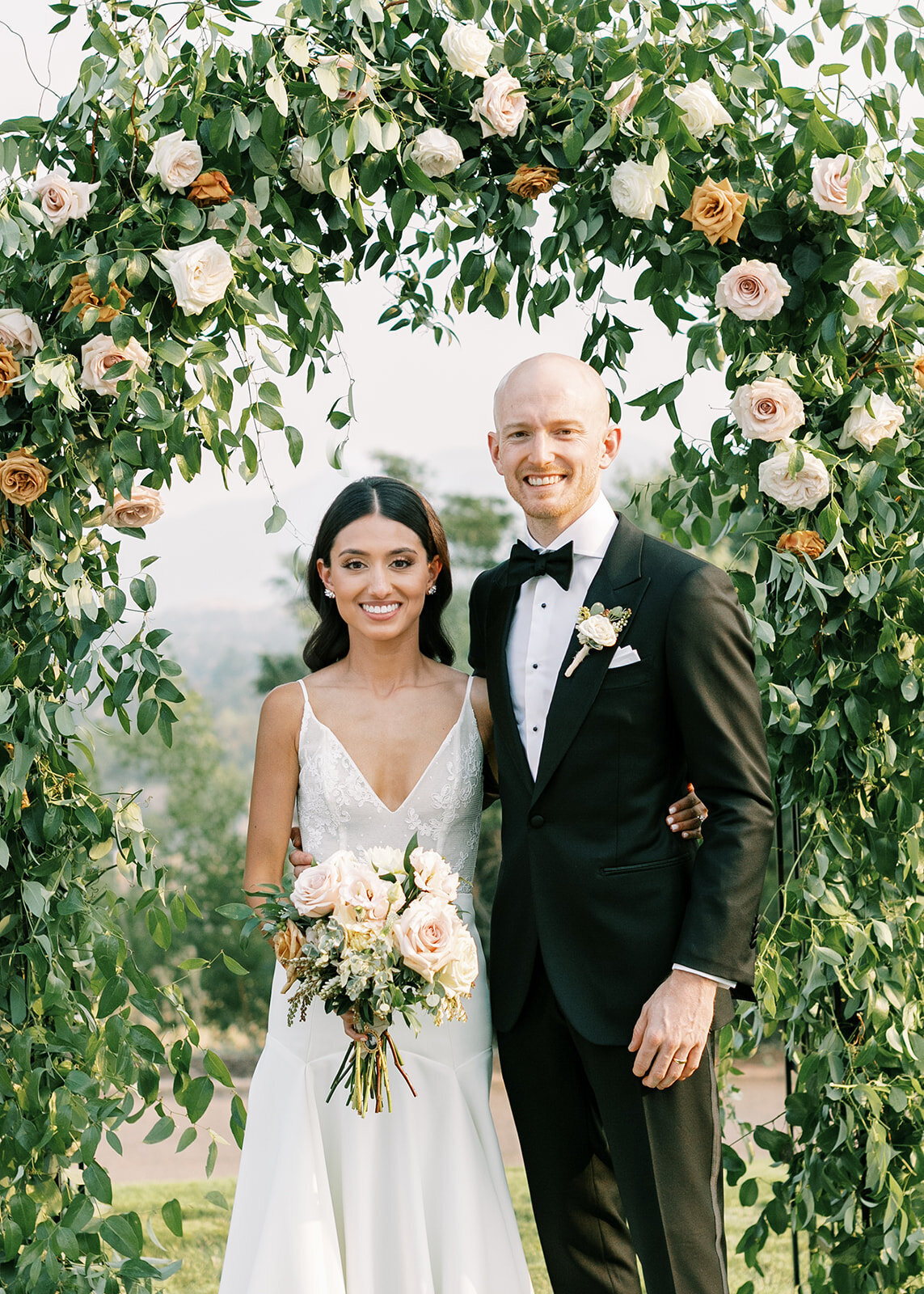 Bride and groom under a custom arbor in Colorado