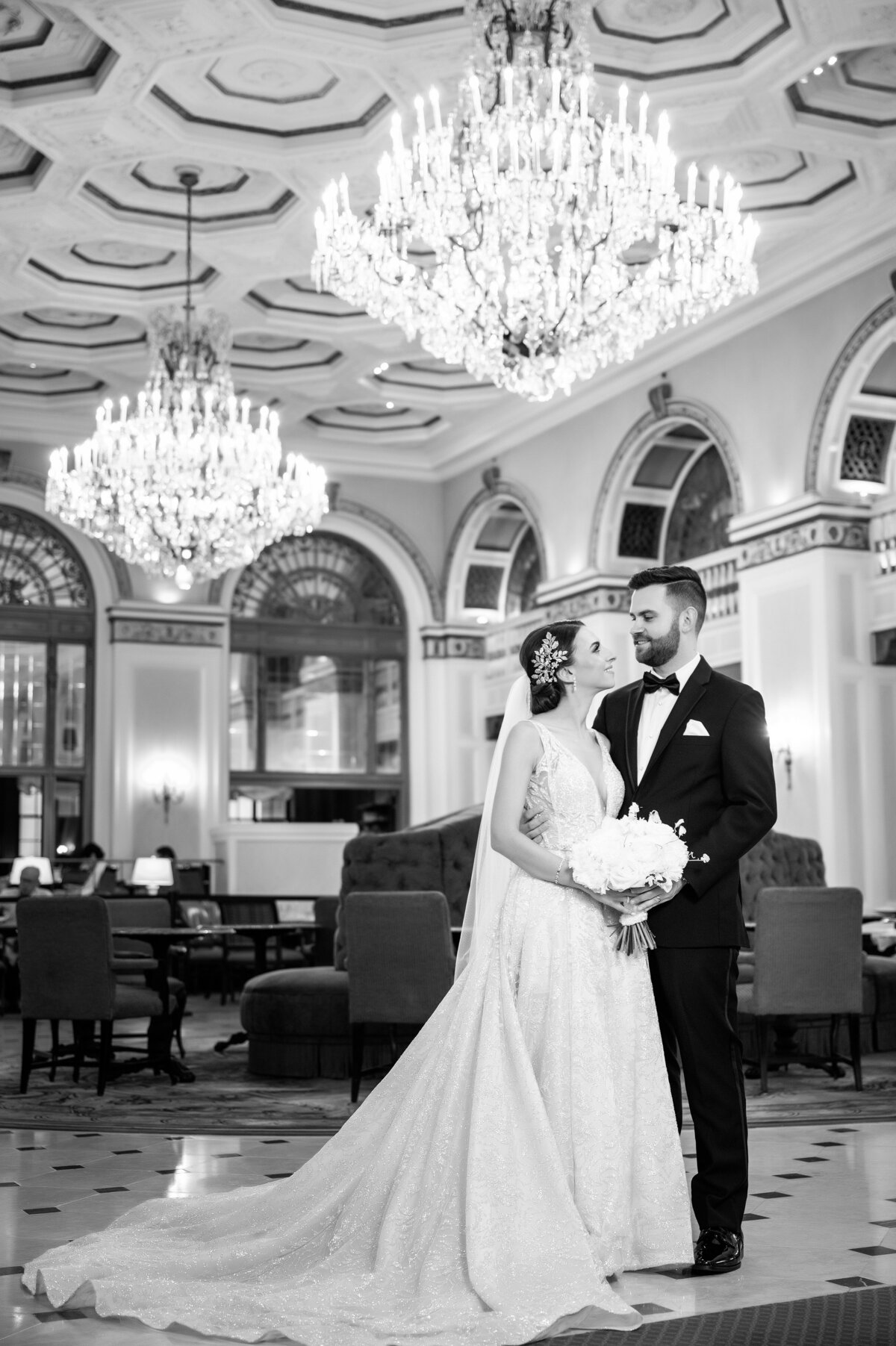 bride and groom smiling for a photo in the omni william penn hotel lobby