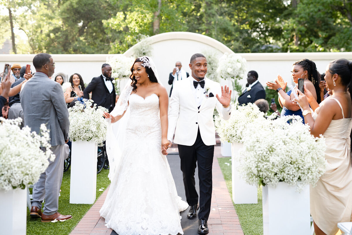 Black couple walking down the aisle together after their wedding ceremony