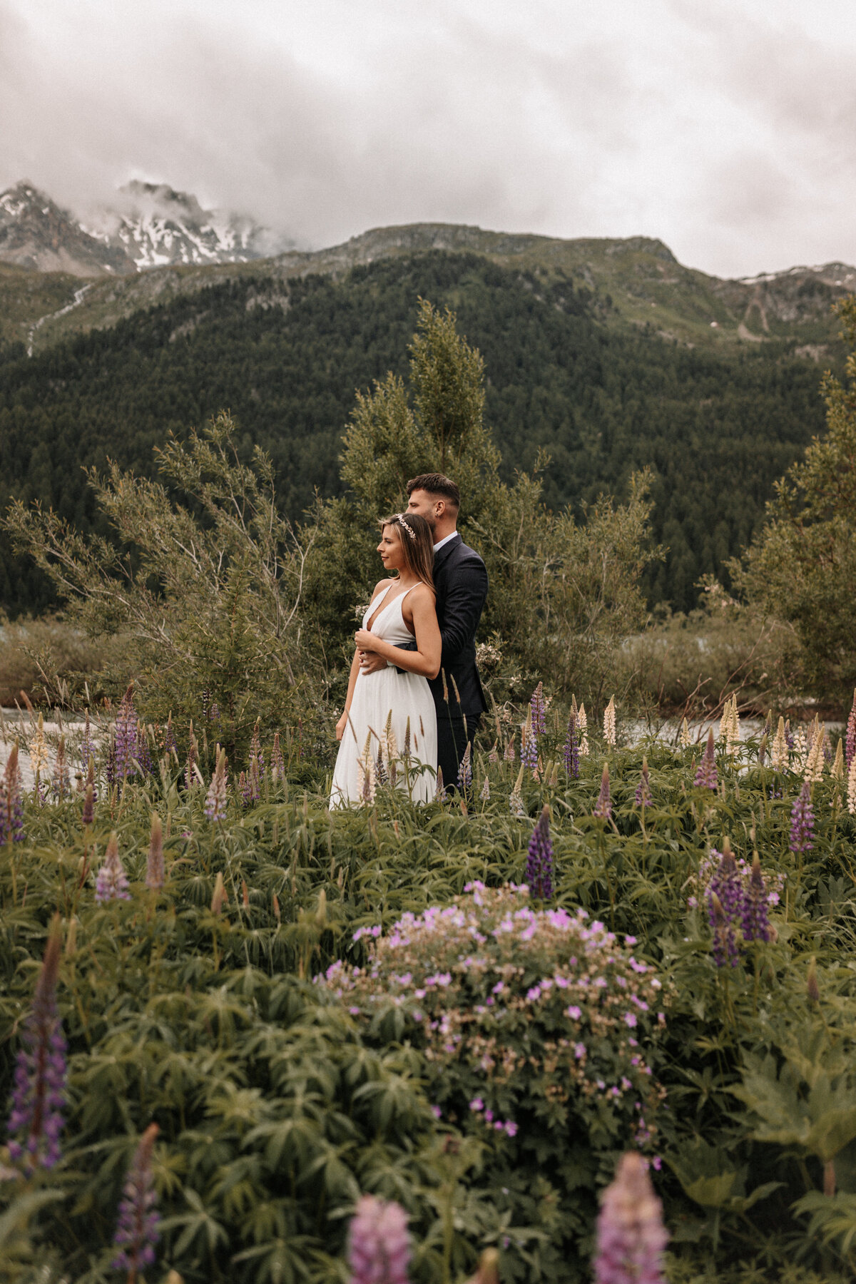 Brautpaar in einem Lupinenfeld in der Schweiz