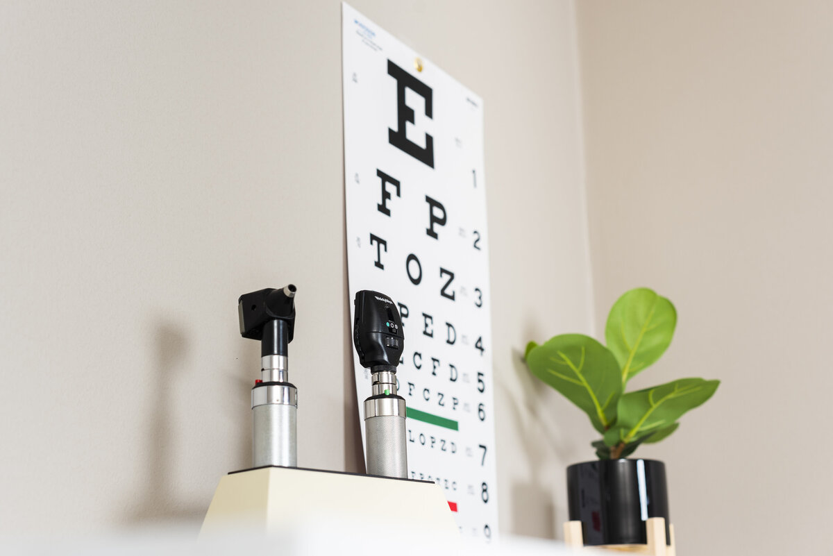 an eye chart, plant, and eye exam tools on top of a cabinet