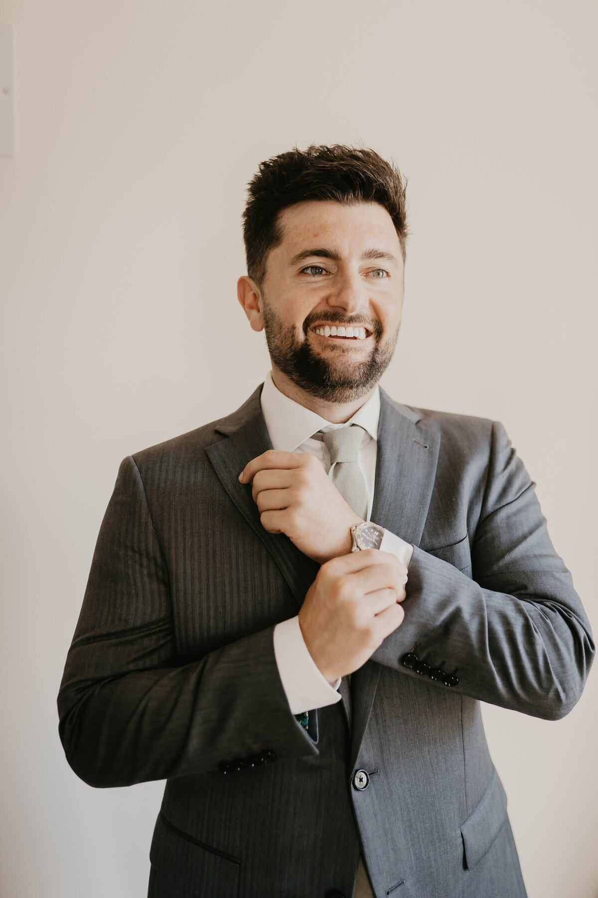 Groom fixing his tie. 
