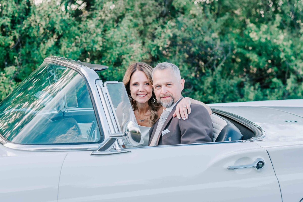Bride and groom are driving a ford thunderbird.