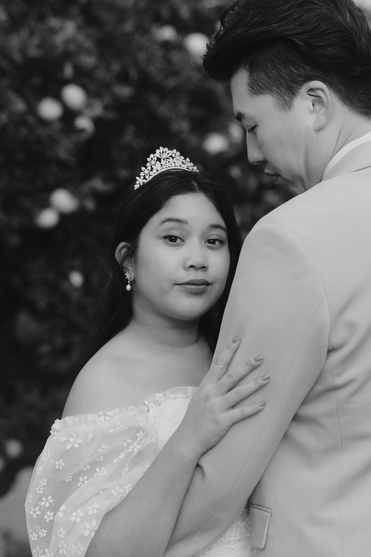 the bride wears a tiara as a head piece and holding the groom