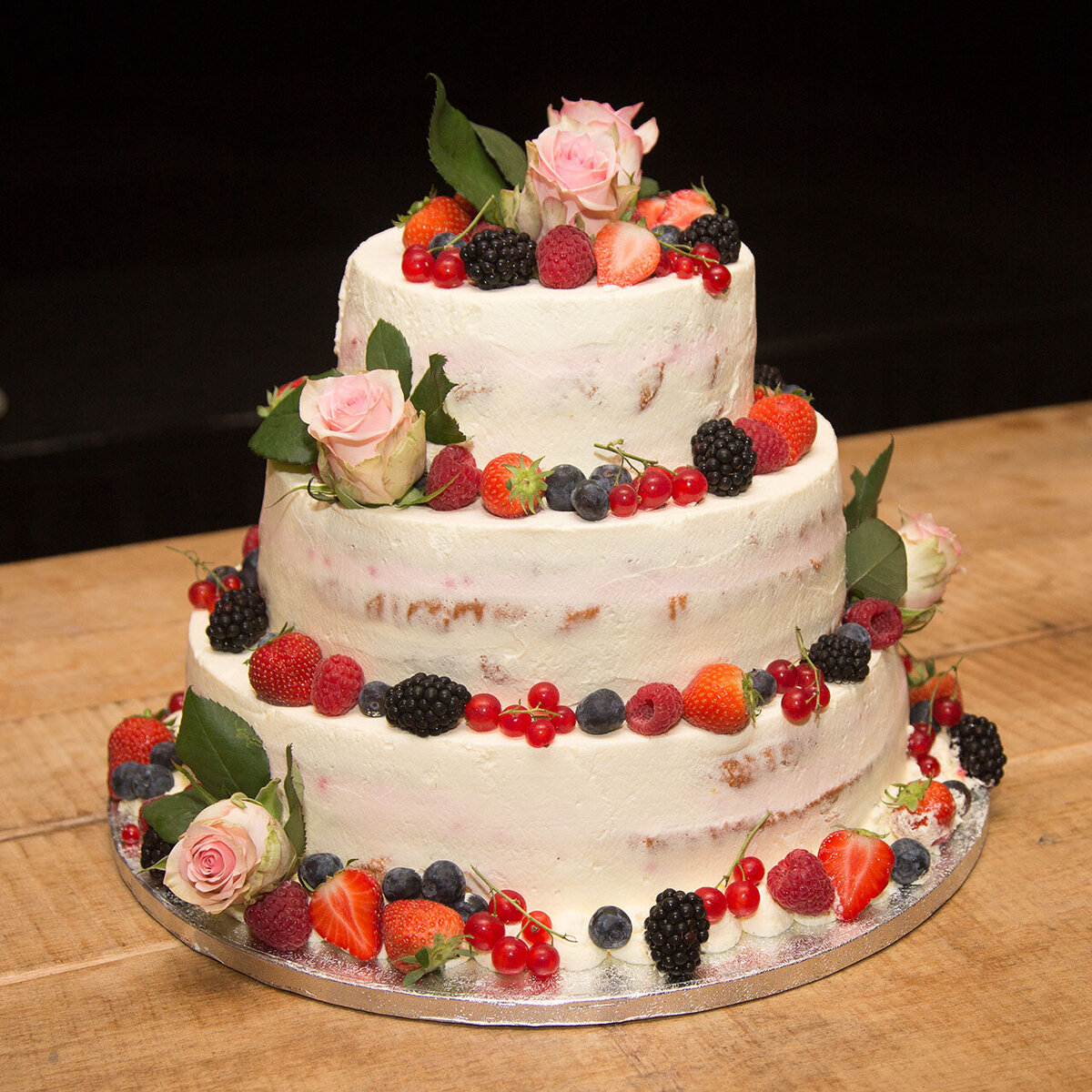 Bruidstaart van Berg's Bakery met rood fruit en rozen