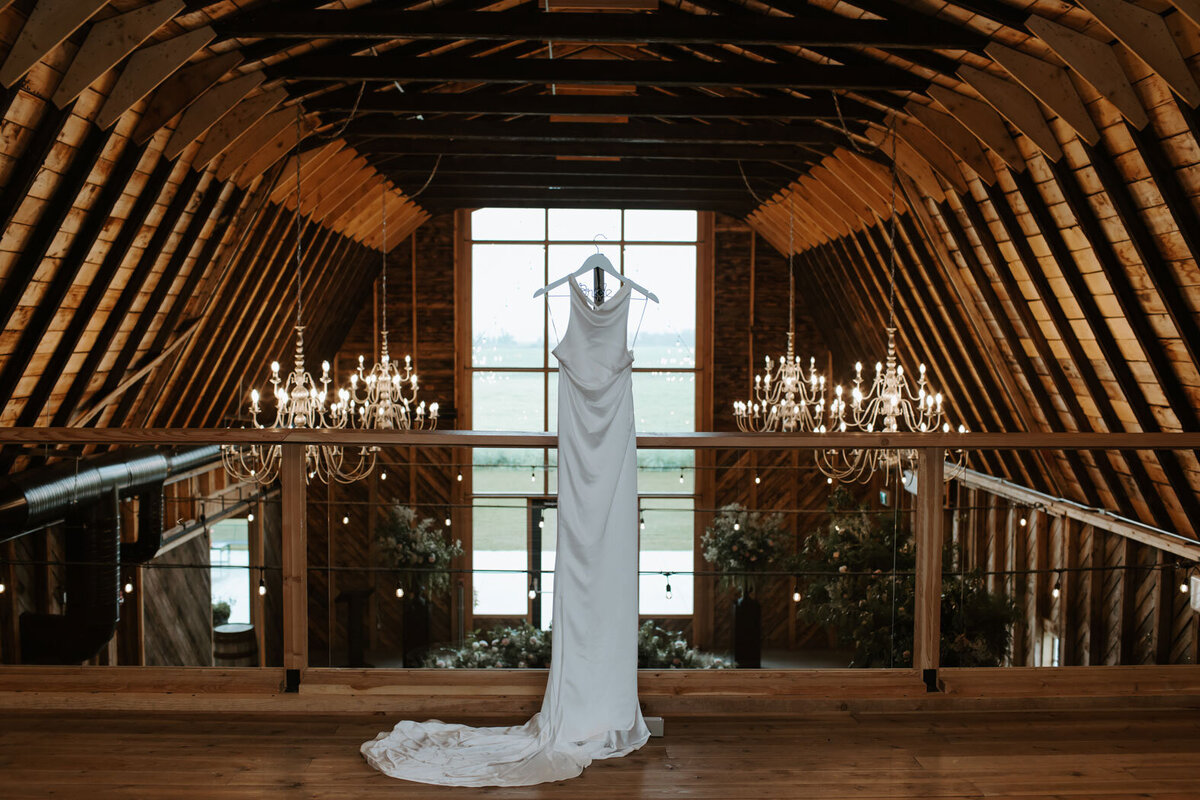 Bridal dress hanging at wedding venue.