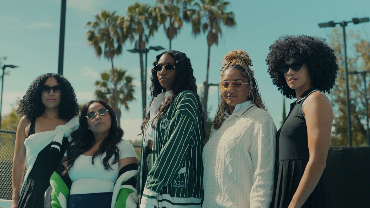 a group of women looking serious on a tennis court.