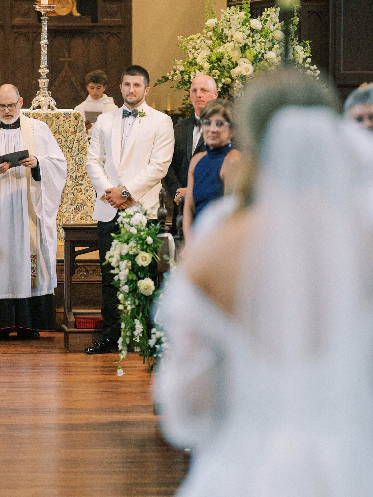 Bride walks down the aisle towards her groom in a church wedding ceremony