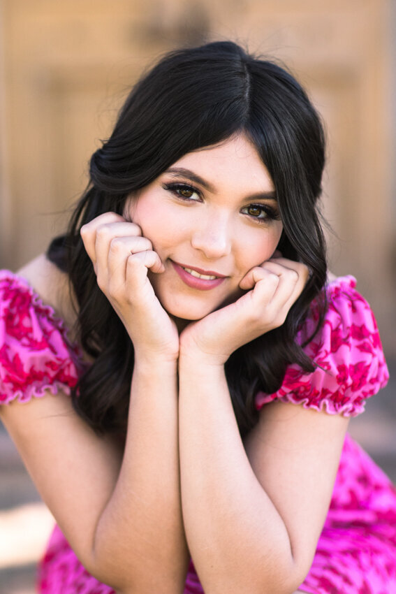 teen girl in pink dress with head in hands