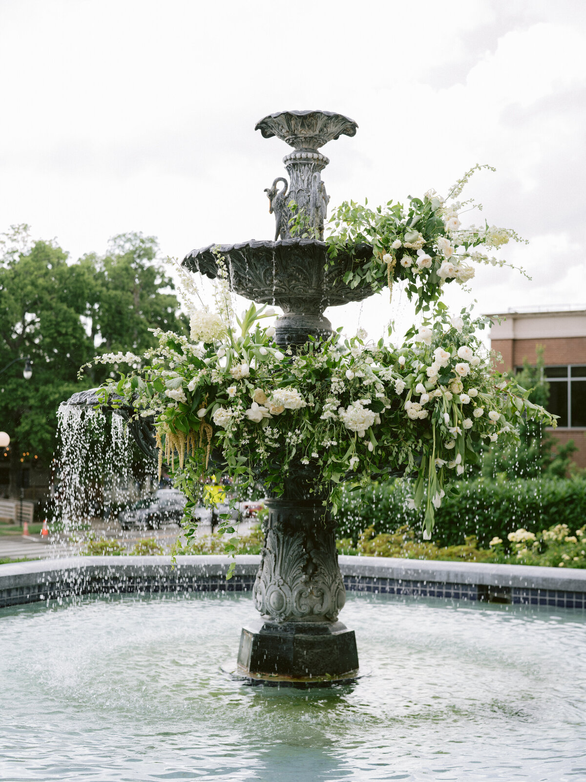 Gorgeous fountain filled with whit hydrangea, tulips, roses and all white flowers with greenery in Nashville black tie wedding
