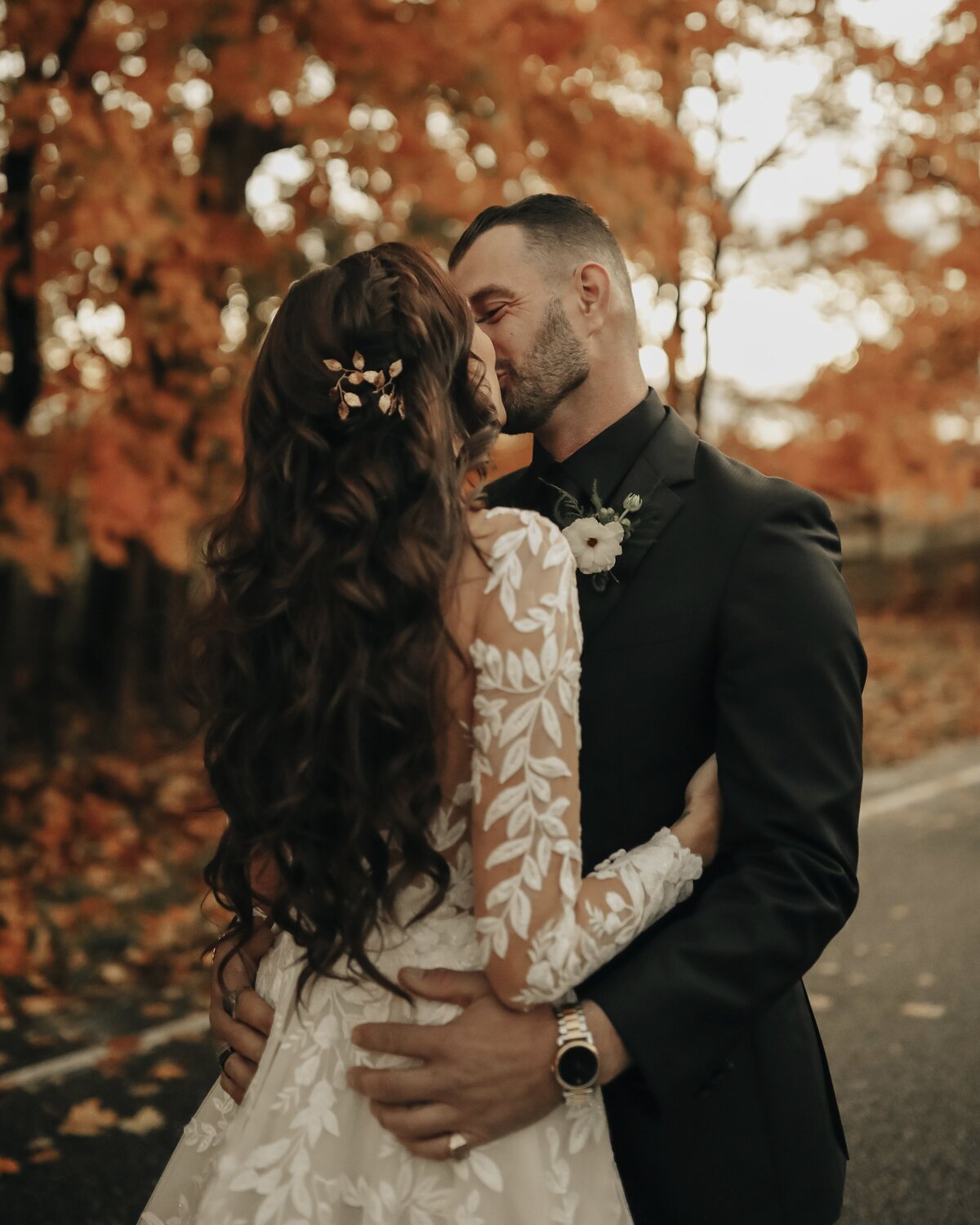 Bride with dark brown hair and curls with a braid kissing groom