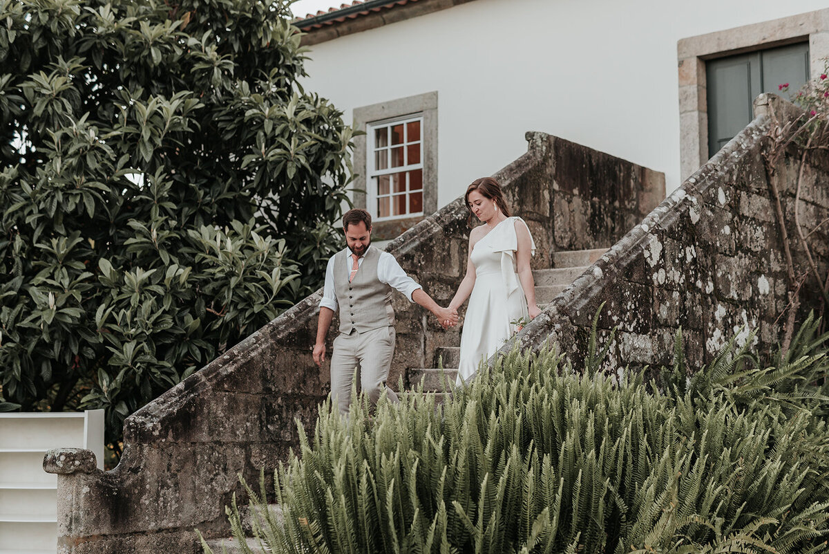 Bride & Groom walking hand in hand down the steps of Casa Grande de Fontao at their wedding in Portugal