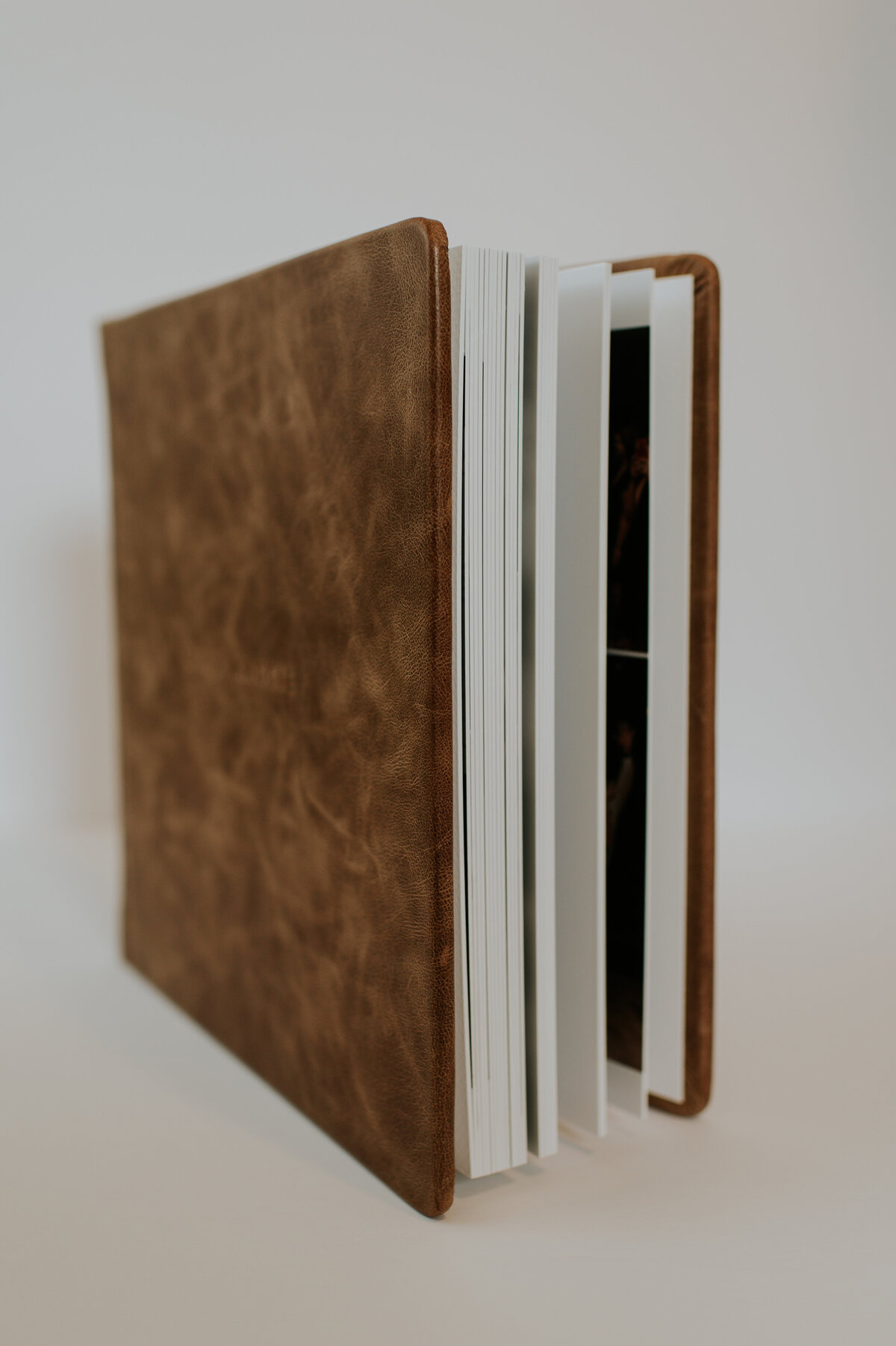 Two stacked leather-bound wedding albums