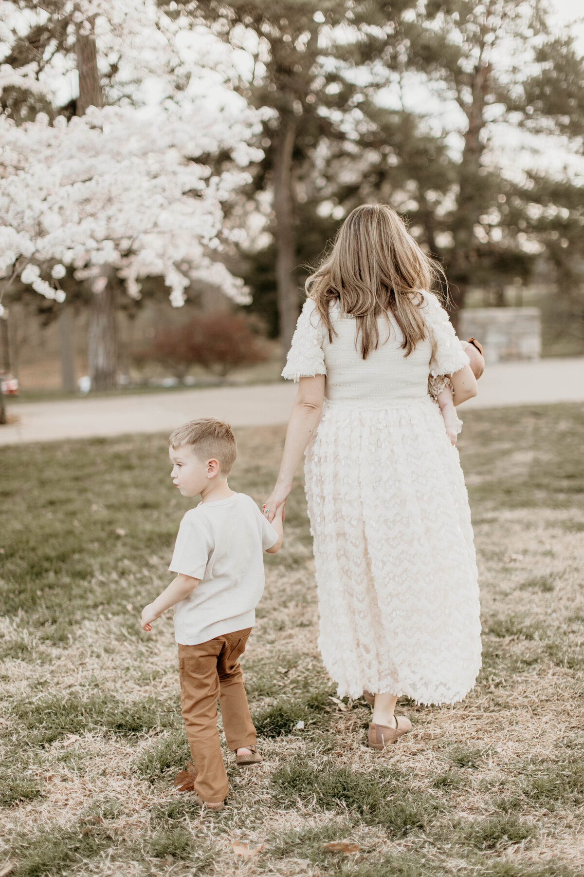 Mom walking away with young toddler boy in hand. 