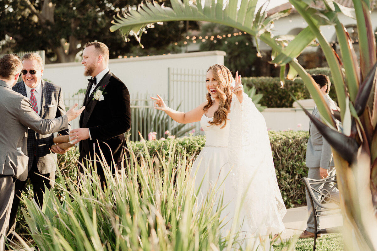 bride and groom make an entrance into cocktail hour at spanish hills country club wedding captured by los angeles wedding photographer magnolia west photography