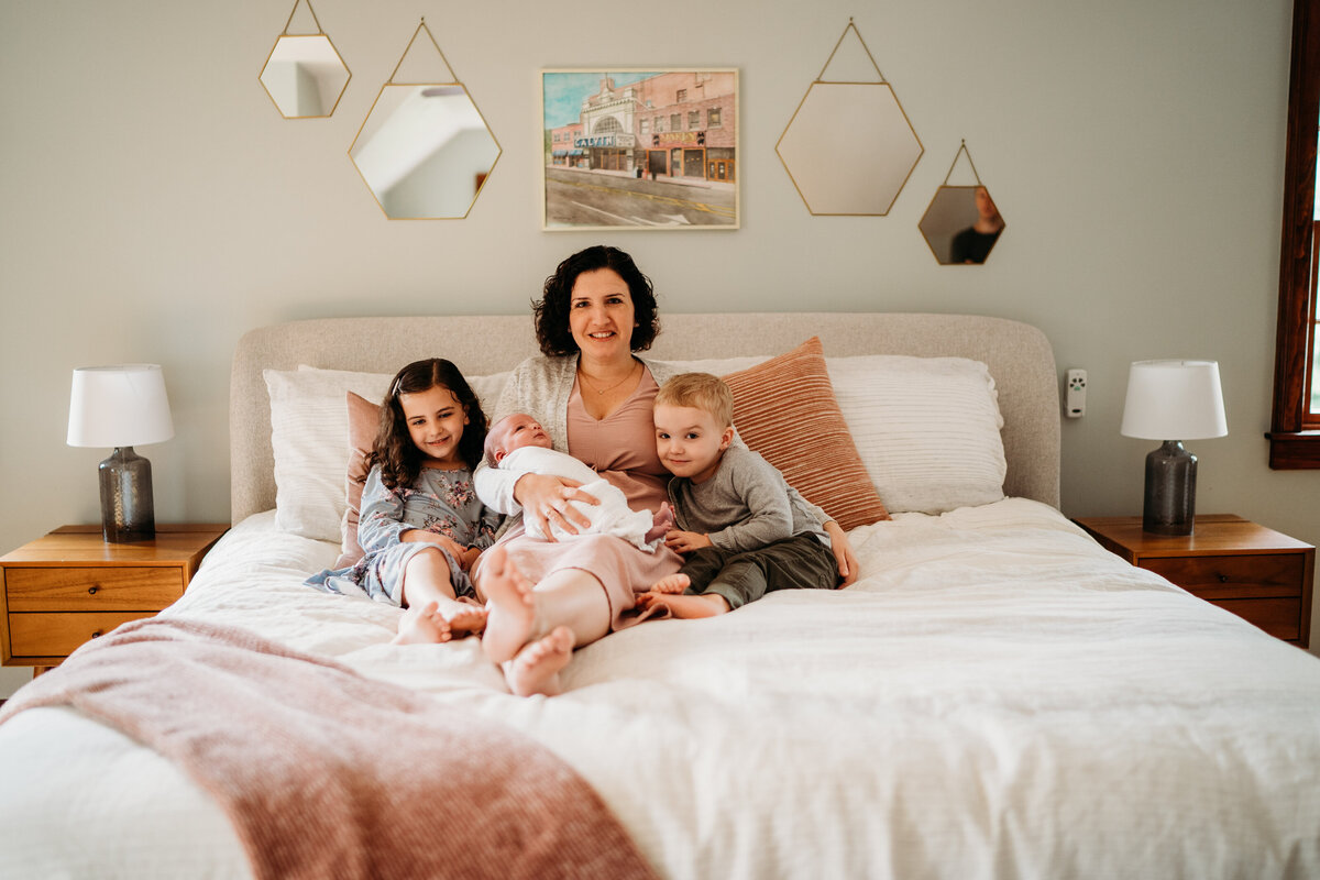 mom sitting on a bed with her kids