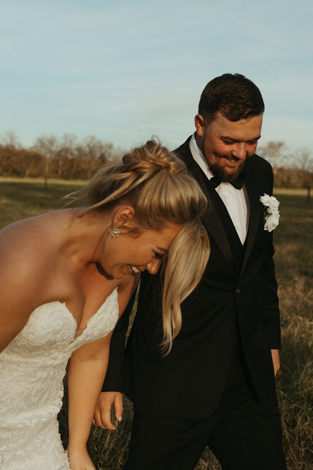 couple laughing on wedding day as sun sets