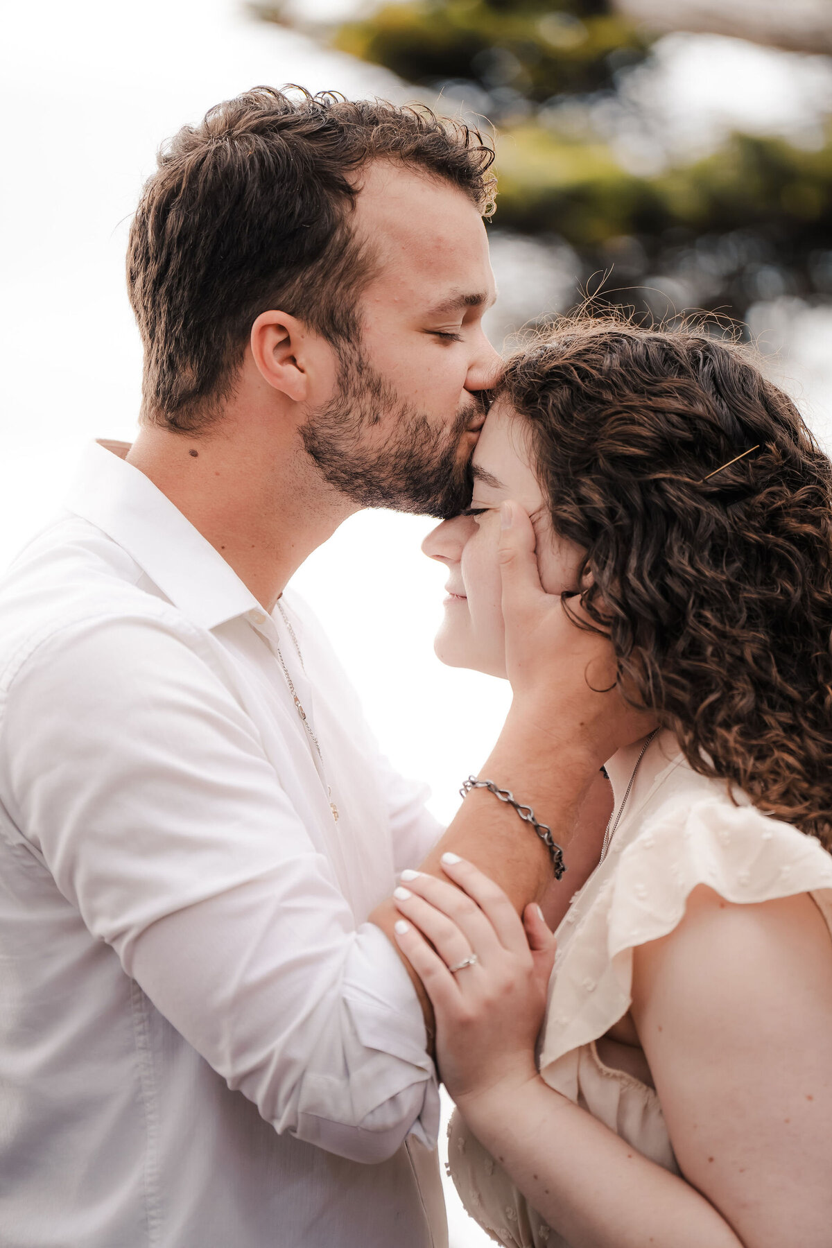a man kissing his fiance on the forehead