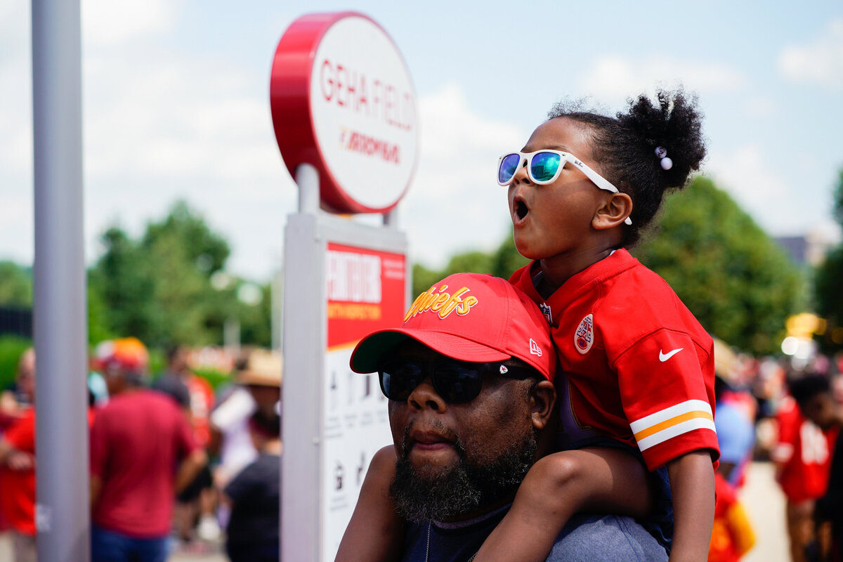 kansas-city-sports-photography-chiefs-0003-fan-carrying-child-in-red-gear