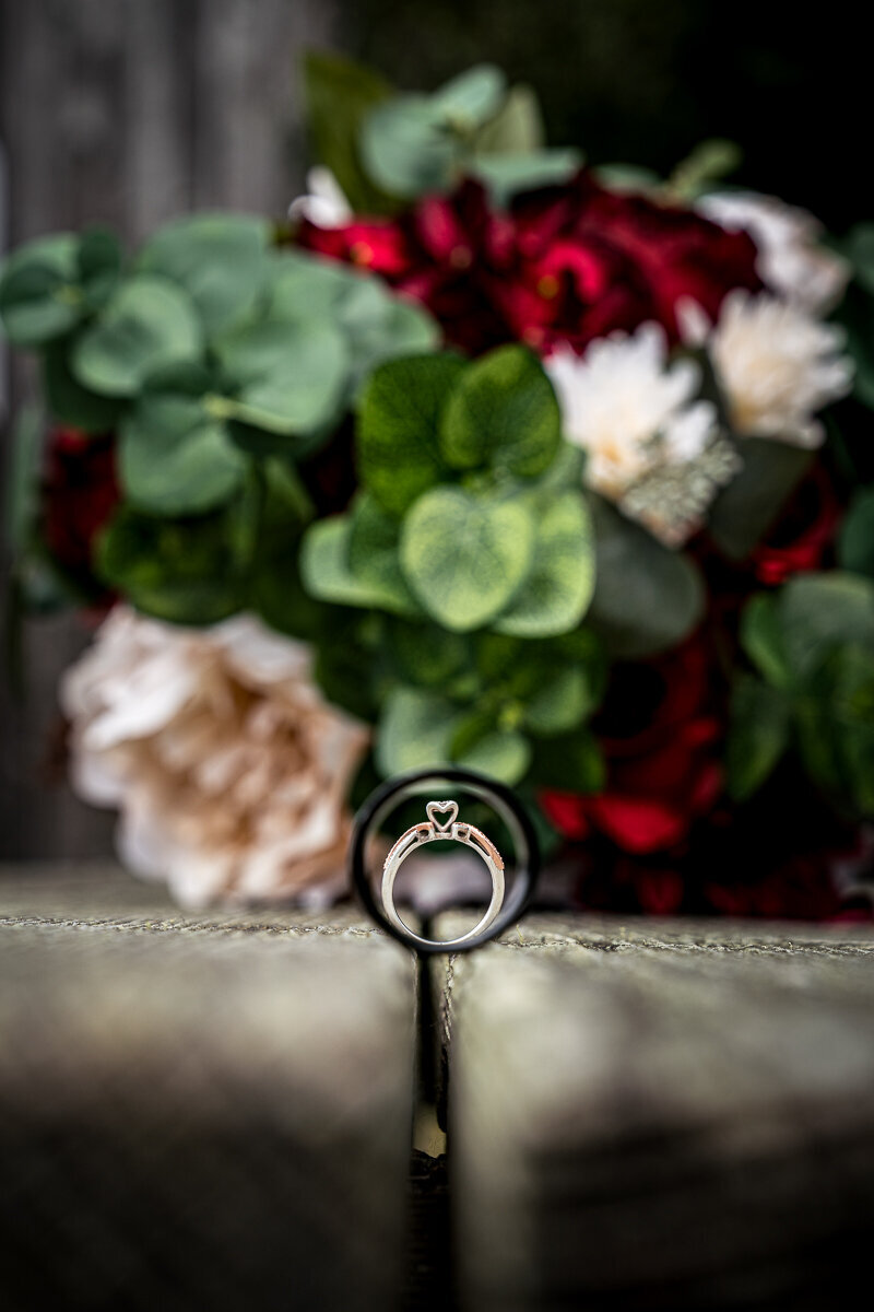 A stunning close-up of wedding rings elegantly displayed in front of the bride’s bouquet in Humboldt, CA, capturing the timeless beauty and romance of the special day.