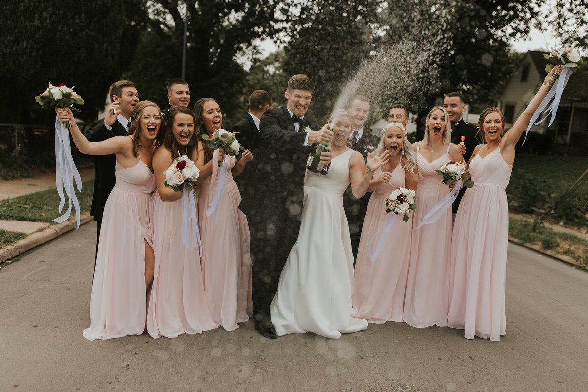 Bridal Party popping champagne during their classic midtown wedding  at the Omar in Omaha, Nebraska