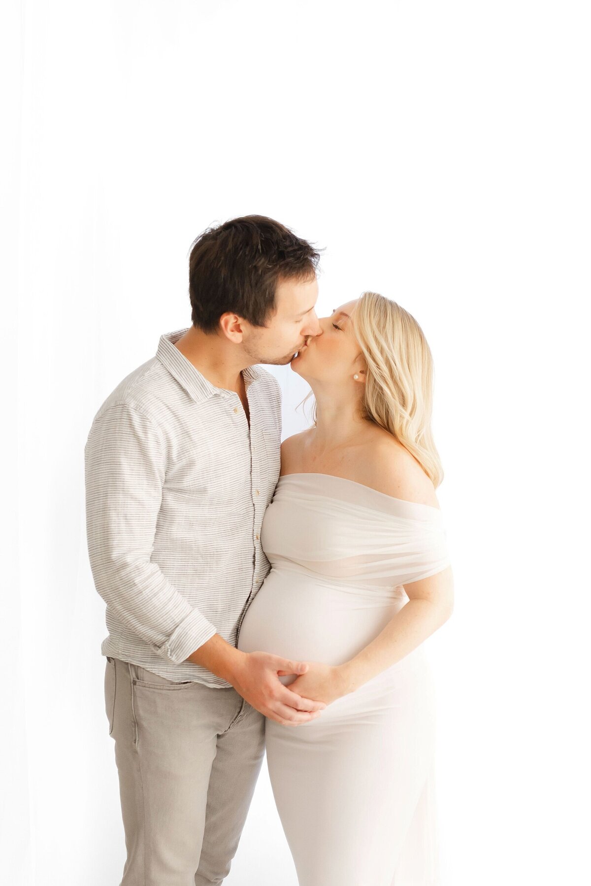 expecting parents kissing by maternity photographer in boston​