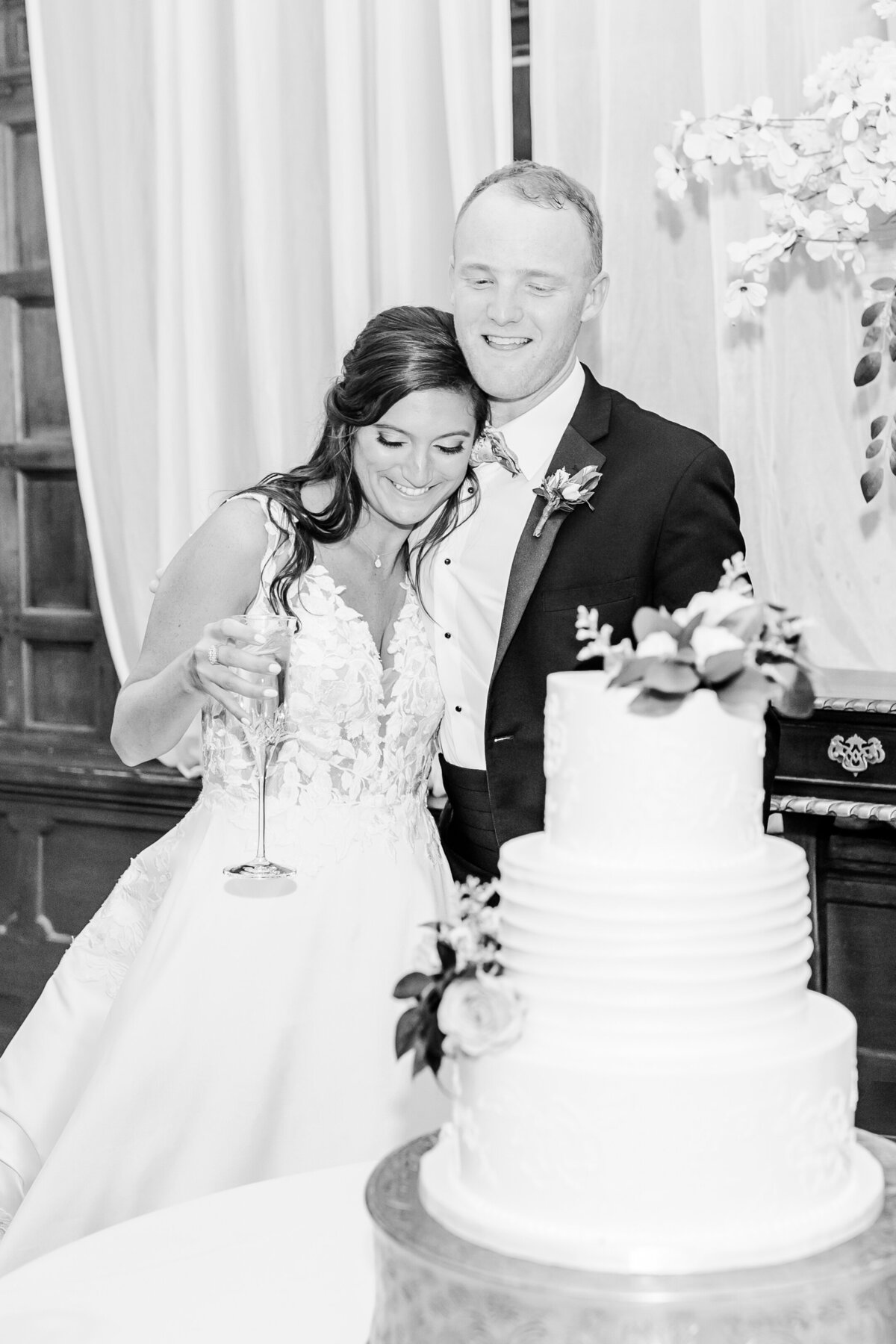 bride and groom looking at wedding cake