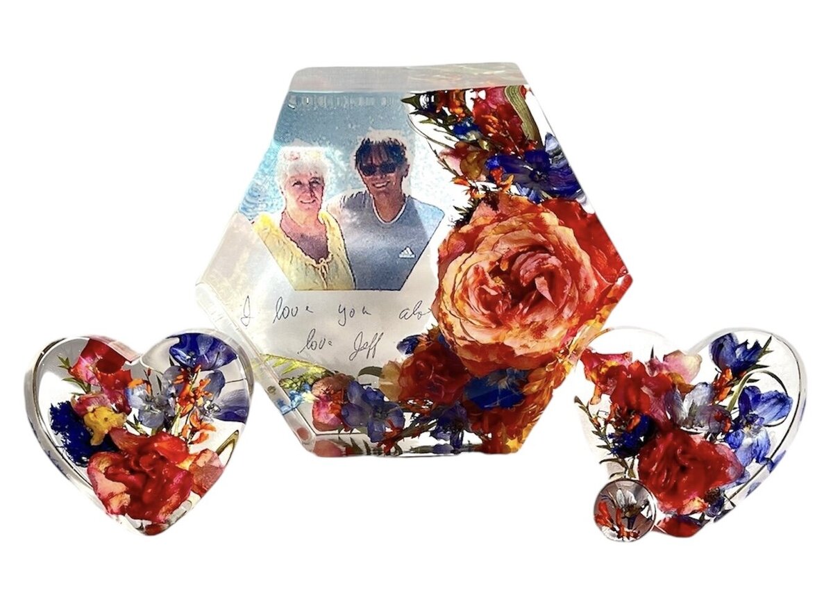 
hexagon resin block with bright orange and blue funeral flowers preserved alongside photo and loved ones hand writing as a timeless family keepsake
