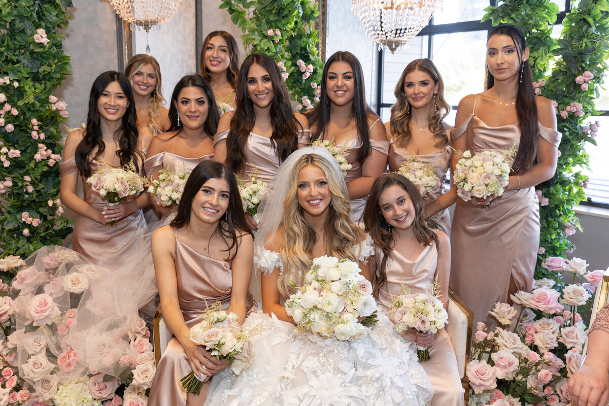 A bride sitting down surrounded by her bridesmaids