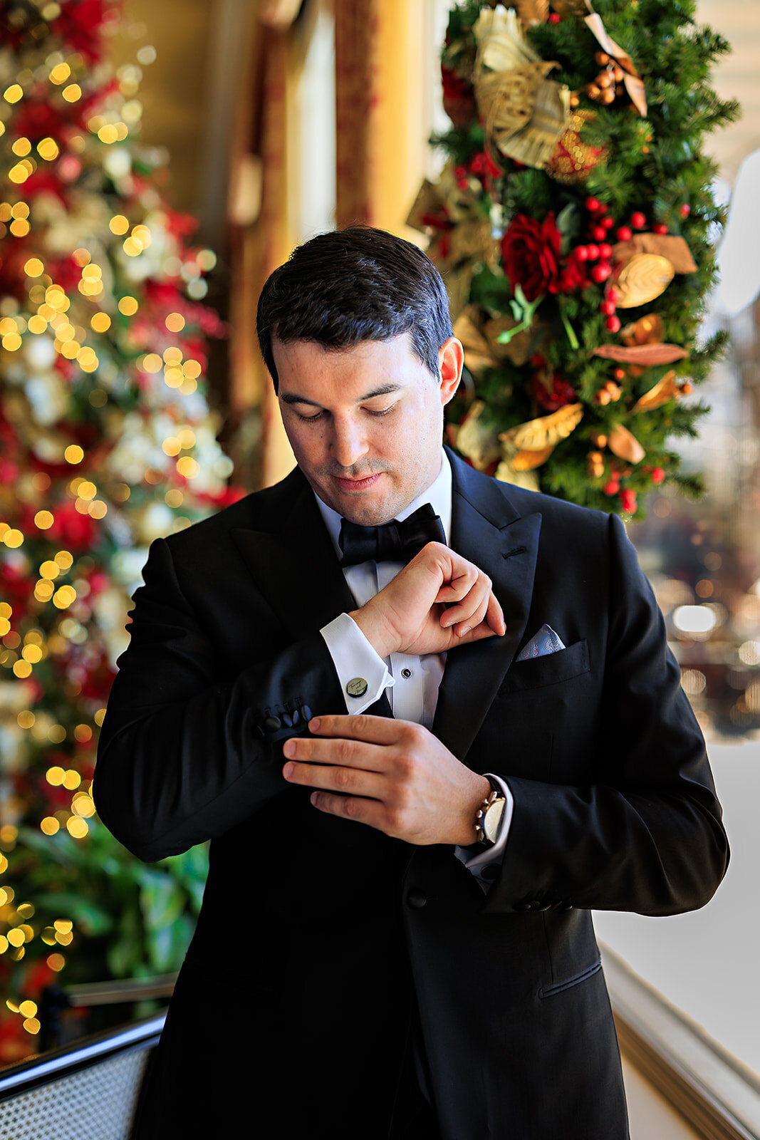 The groom adjusts his cuffs on his wedding day .