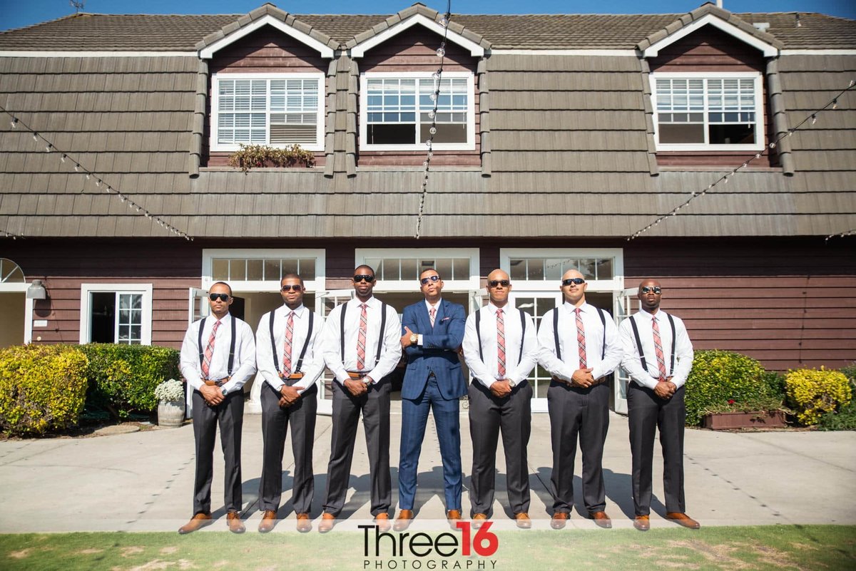 Groom and his Groomsmen pose together wearing sunglasses