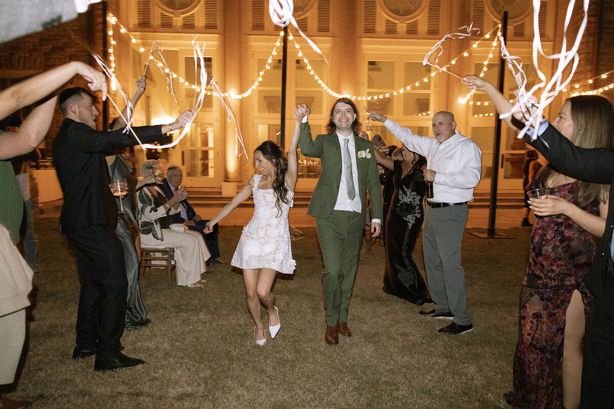 Bride and groom run through sendoff streamers at the end of their wedding night.