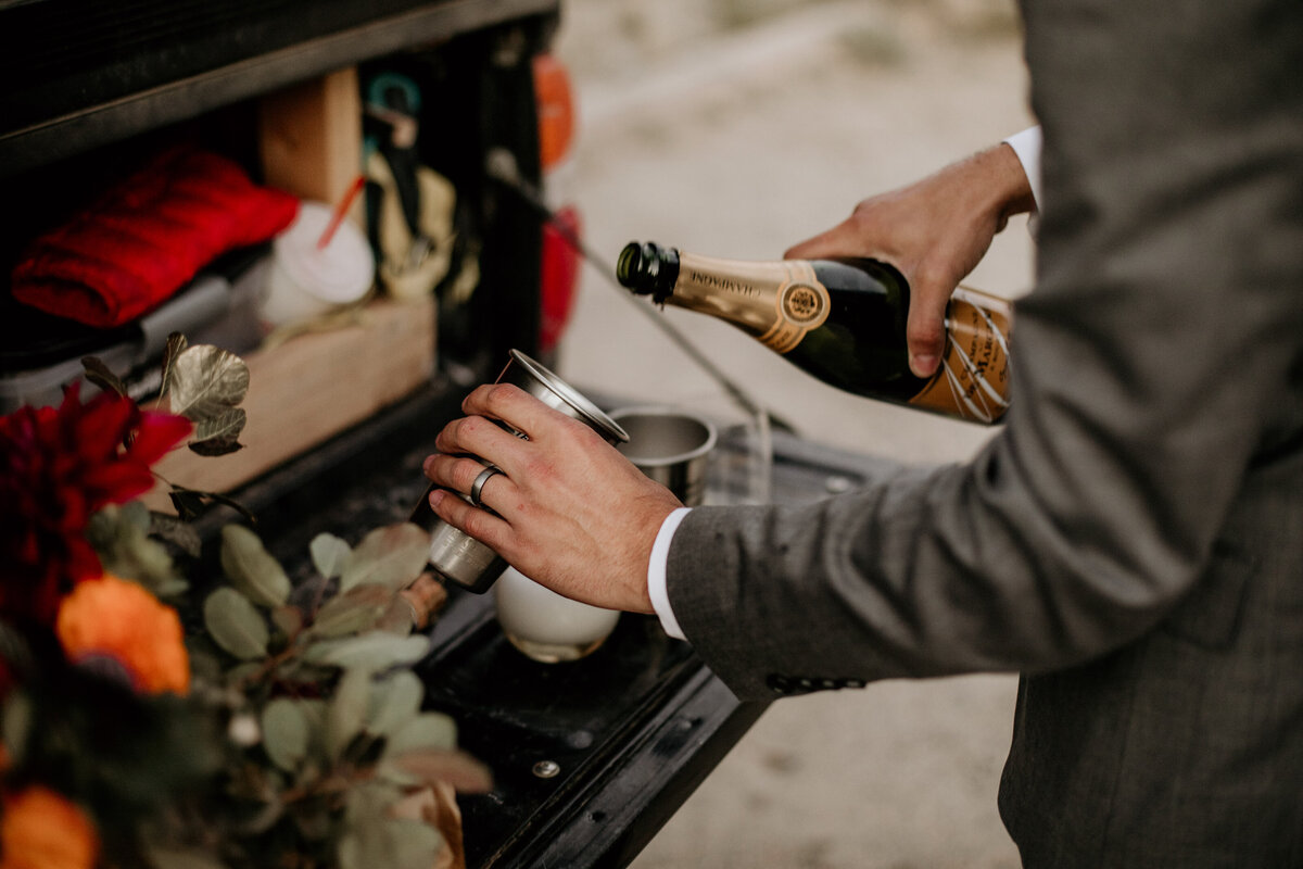 grooms hands pouring champagne