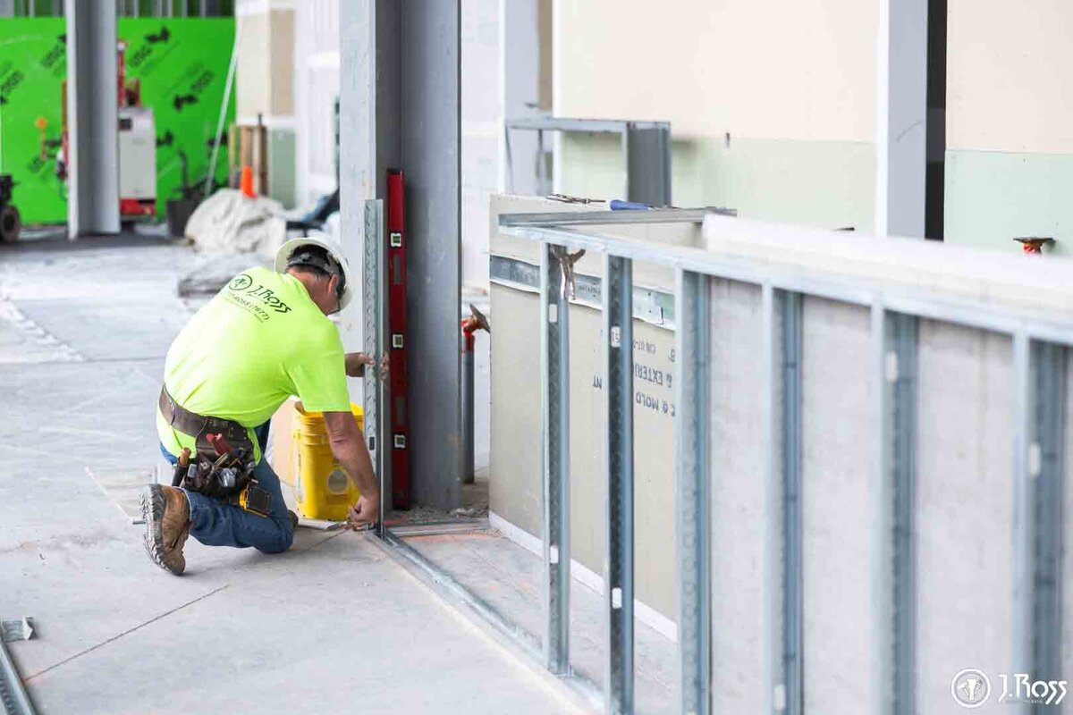 A close-up of a J.Ross Painting & Drywall crew member working on commercial framing for the ETSU Academic Building project.